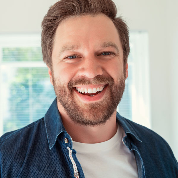 man in jean jacket smiling