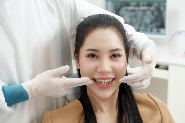 Happy patient smiling confidently after receiving dental implants at a clinic in Norton Shores, MI